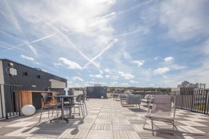 patio con sedie e tavolo sul tetto di FINESTATE Coliving Mairie d'Issy a Issy-les-Moulineaux