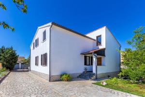 une maison blanche avec une rafale dans l'établissement Neu renovierte Ferienwohnung mit Klima, WLAN, Terrasse und Grill, à Pula