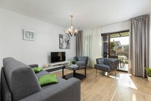 - un salon avec un canapé, deux chaises et une télévision dans l'établissement Neu renovierte Ferienwohnung mit Klima, WLAN, Terrasse und Grill, à Pula