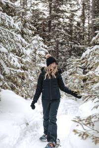 a woman walking through the snow on skis at Estérel Resort in Esterel