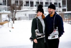 a man and a woman standing in the snow holding shoes at Estérel Resort in Esterel