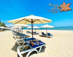 - une rangée de chaises longues et de parasols sur une plage dans l'établissement The Sea Luxury Nha Trang Apartment, à Nha Trang