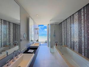 La salle de bains est pourvue de 2 lavabos et d'une baignoire avec vue sur l'océan. dans l'établissement The Sea Luxury Nha Trang Apartment, à Nha Trang