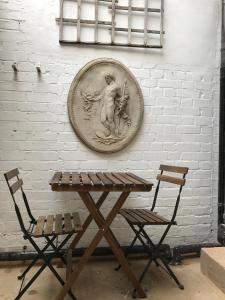 une table en bois et deux chaises à côté d'un mur dans l'établissement Camden Terrace, à Londres