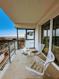 - Balcón con sillas, sofá y mesa en White Suite, 50 meters to beach, 10th floor, beautiful view, Baltic Best, en Dziwnówek