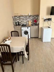 een keuken met een tafel en een keuken met een wasmachine bij Apartment near Tskaltubo spa restort in Tskaltubo