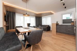 a dining room and living room with a table and chairs at A CASA Serenity in Serfaus