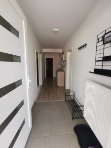 a hallway with white walls and a room with a table at Apartment Mejdan in Tuzla