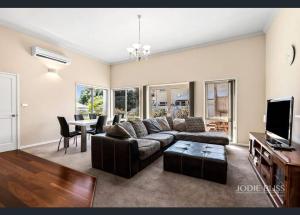 ein Wohnzimmer mit einem Sofa und einem Tisch in der Unterkunft Freestanding house with ocean view in Port Campbell