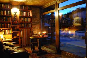 a living room with a large window and a table with candles at Hotel Bellevue in Champoluc