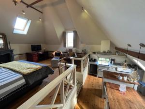 een zolderkamer met een bed en een keuken bij Plompeblad Suite Giethoorn in Giethoorn