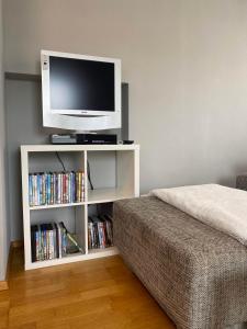 a tv sitting on a white shelf with dvds at Wohnung im Grünen am Stadtrand, 50 m2, eigener Garten mit Terrasse, eigener Eingang, kostenloses Parken in Salzburg