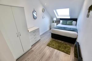 una camera con letto, cassettiera e finestra di Luxury 2 Bedroom Apartment Southsea - Free Parking a Portsmouth