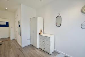 una camera da letto bianca con cassettiera e specchio di Luxury 2 Bedroom Apartment Southsea - Free Parking a Portsmouth