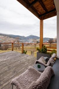 une terrasse en bois avec une table et des chaises. dans l'établissement Yo Hotel, à Bukovel