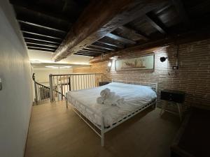 una camera con un letto bianco su un muro di mattoni di Venus Two-Floored Stylish Apartment in the City Center a Firenze