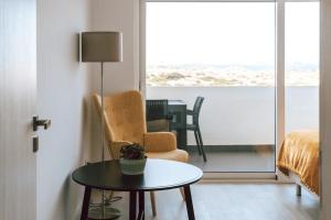 uma sala de estar com uma mesa e uma cadeira em Sea View Baleal em Peniche