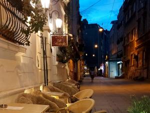 - une table et des chaises dans une rue la nuit dans l'établissement Villa Skadarlija, à Belgrade