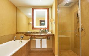 bagno con lavandino, vasca e doccia di The Westin Warsaw a Varsavia