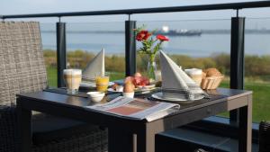 DrochtersenElbstrand Resort Krautsand - Hotel Elbstrand的一张桌子,上面有食物和饮料,还有一艘模型船