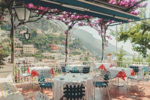 un ristorante con tavoli e sedie e vista sulla città di Hotel Poseidon a Positano