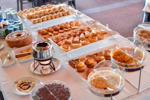 una mesa llena de diferentes tipos de repostería y postres en Hotel Solverde Spa and Wellness Center, en Vila Nova de Gaia