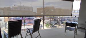 two chairs on a balcony with a view of a city at OD'A Apartaments in Roses