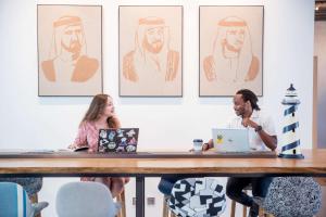 un grupo de personas sentadas en una mesa con ordenadores portátiles en Rove La Mer Beach, Jumeirah, en Dubái