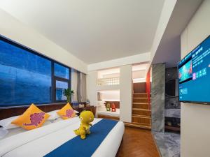 a yellow teddy bear sitting on a bed in a room at 張家界武陵源北岸輕奢客棧 森林公園店 in Zhangjiajie