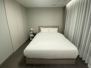 a large white bed in a small room at HOTEL THE DESIGNERS LYJ SUITE YEOKSAM in Seoul