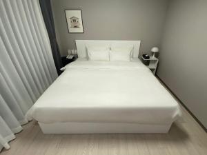 a large white bed in a small room at HOTEL THE DESIGNERS LYJ SUITE YEOKSAM in Seoul