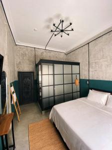 una camera con letto e lampadario a braccio di Sundays Café & Hotel a Phnom Penh