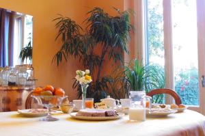 a table with food and fruit on a white table cloth at Teodora B&B in Milan