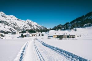 锡尔斯玛丽亚Hotel Chesa Pool的雪地里覆盖着雪地,有雪地的轨道