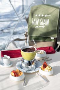 - une table avec un bol de nourriture et des assiettes de desserts dans l'établissement Sport & Wellnesshotel San Gian St. Moritz, à Saint-Moritz