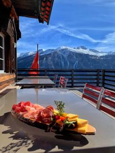 une assiette de nourriture sur une table avec des montagnes en arrière-plan dans l'établissement Hotel Restaurant Capricorns, à Wergenstein