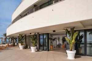 a building with potted plants on a patio at ME Sitges Terramar in Sitges