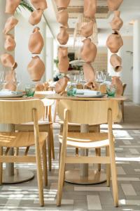 a dining room with tables and chairs with glasses at ME Sitges Terramar in Sitges