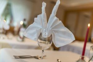 ein Glas mit einer weißen Blume auf dem Tisch. in der Unterkunft Pension Prack in Bruneck