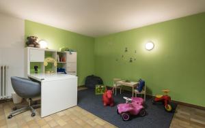 ein Kinderzimmer mit grünen Wänden und Spielzeug auf dem Boden in der Unterkunft Pension Prack in Bruneck