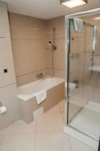 a bathroom with a shower and a tub and a sink at Silver Mountain, Poiana Brasov - Forest Crib in Braşov