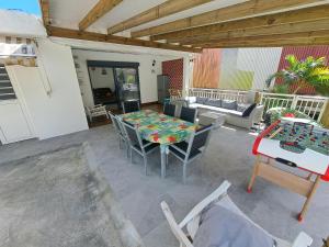 een patio met een tafel en stoelen en een bank bij Chambres d'hôtes dans Villa à Chateauboeuf in Fort-de-France