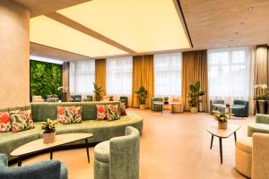 a hotel lobby with couches and tables and windows at Somerset Schönbrunn Vienna in Vienna