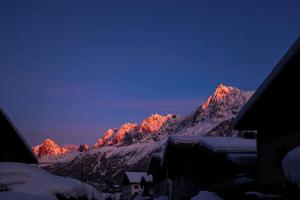 The Historic Chalet Les Allognes Mont-Blanc views في لي أوش: سلسلة جبلية عليها ثلج في الليل