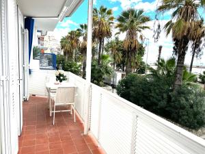 d'un balcon avec une table et des palmiers. dans l'établissement Sitges Seafront Ribera Apartment, à Sitges