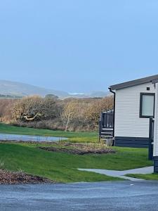 库伯特Cornwall Holiday Cabin with Hot tub & Sea view的路边有标志的白色建筑