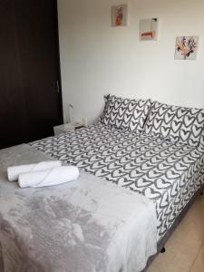 a bedroom with a bed with black and white sheets at Comodo Apartaestudio al Norte de Armenia, con Parqueadero de Carro, en la salida a Salento y Filandia! in Armenia