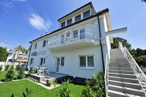 ein weißes Haus mit einer Treppe, die hinauf führt. in der Unterkunft Villa Oliver 1 Siófok in Siófok