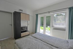 Schlafzimmer mit einem Bett und einer Glasschiebetür in der Unterkunft Villa Oliver 1 Siófok in Siófok