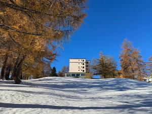 un edificio en la cima de una colina nevada en Hotel Belmont, en Crans-Montana